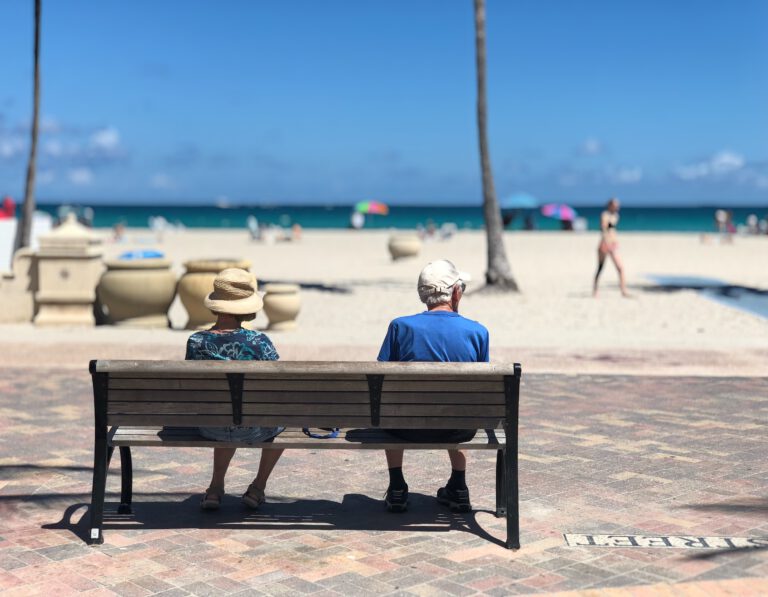 Widok od tyłu na kobietę i mężczyznę w podeszłym wieku na ławce przy plaży